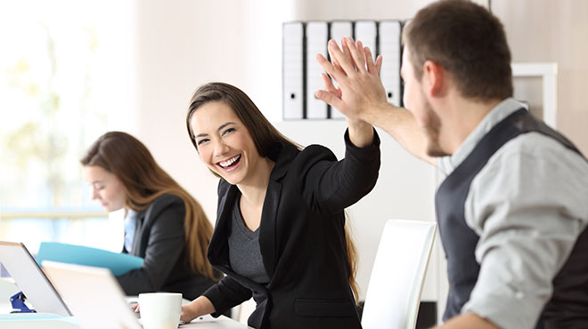 People high fiving in office