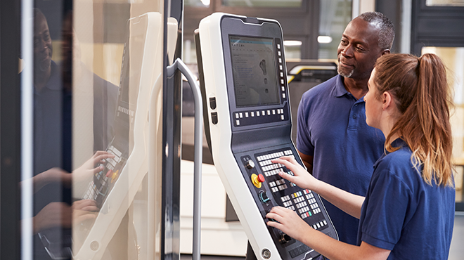 2 people setting CNC machine