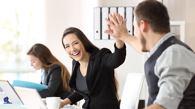 People high fiving in office
