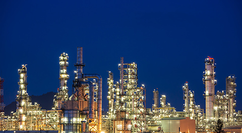 petrochemical plant at night lit up with lights