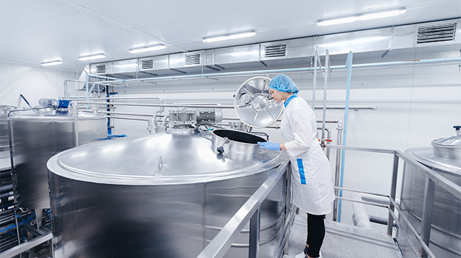 woman in lab coat inspecting a tank