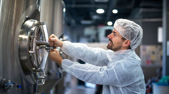 man in hair net closing tank door