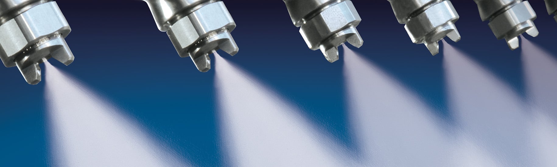 stainless steel nozzles spraying water on blue background