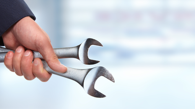 hand holding two wrenches
