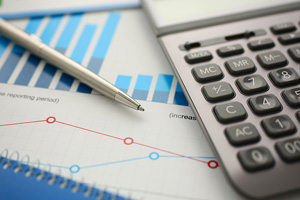 calculator and pen laying on chart