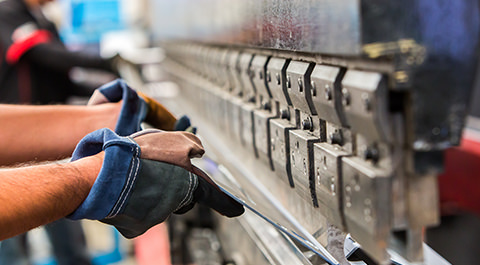 mains d'un ouvrier dans une usine de traitement des métaux