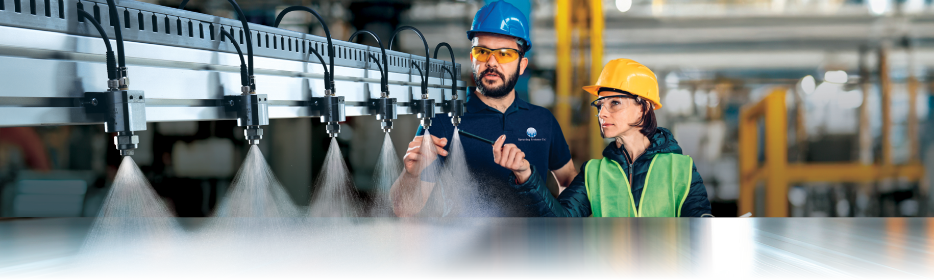 man and woman in hard hats inspecting spray nozzles