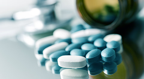 spilled bottle of blue and white pills