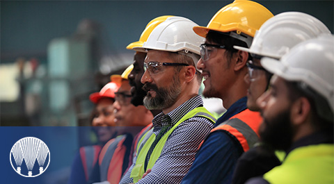 group of people in hard hats with spray logo