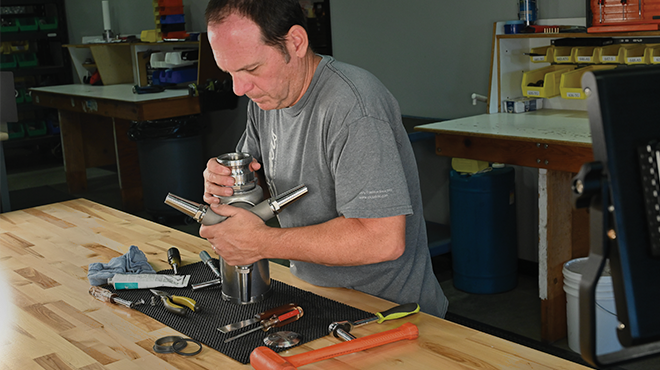 man repairing a tank cleaning nozzle