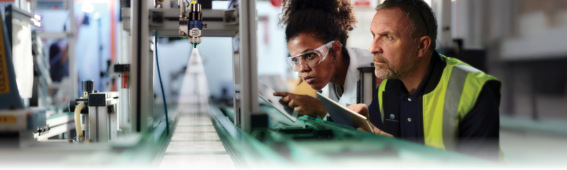 man and woman with notepads inspecting nozzle spraying