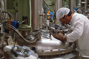 man in lab coat looking into a tank